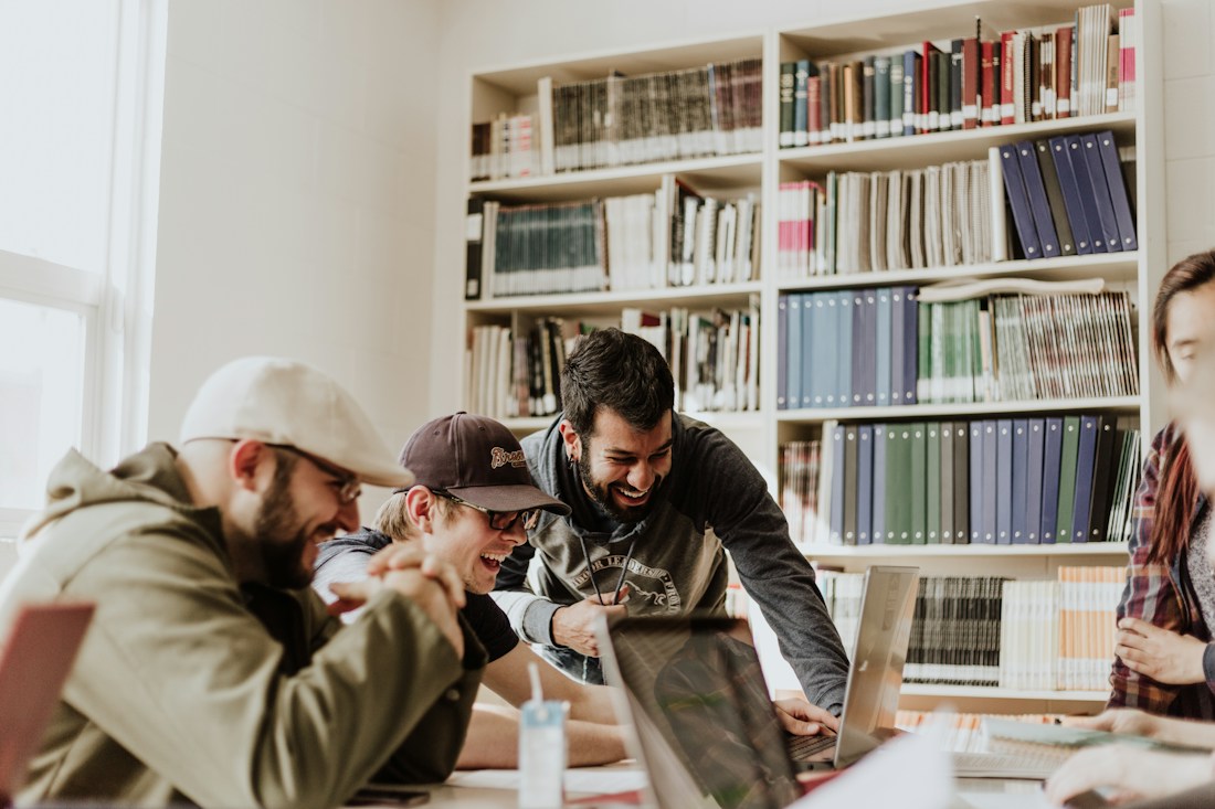 Jóvenes compartiendo ideas junto a una biblioteca